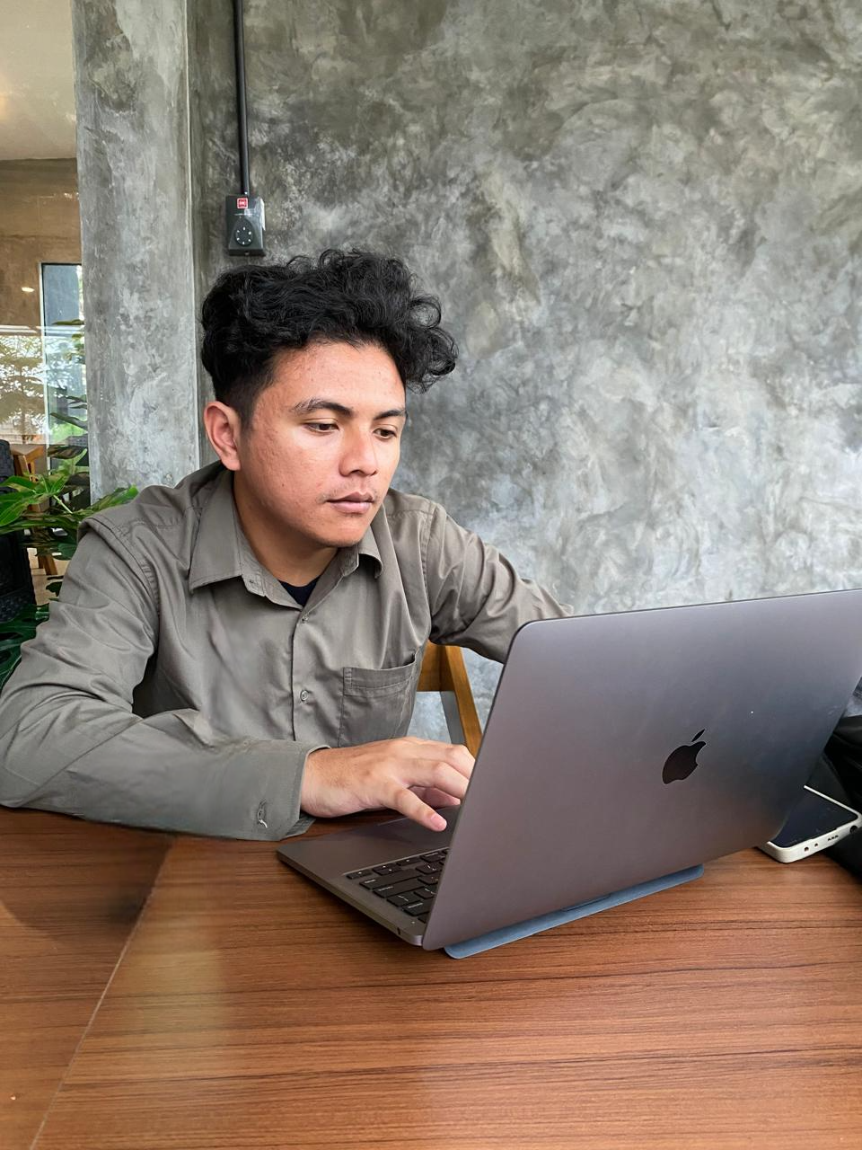 Seorang programmer fullstack sedang bekerja di depan laptop dengan kode di layar, suasana modern dan profesional